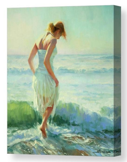 Woman wading in surf at the ocean.