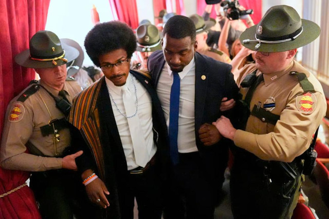 Justin Pearson and his brother KeShaun, both young black men, being arrested by white state trooper scum in a government building. They are both wearing suits and are cooperating.