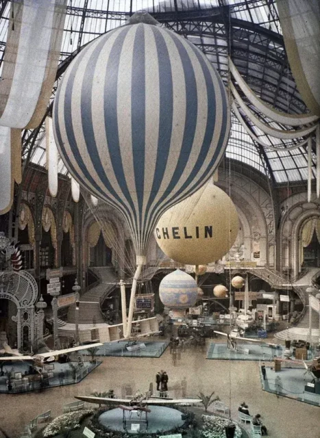 Large blue and white striped air balloon, inflated, inside a capacious exhibition space