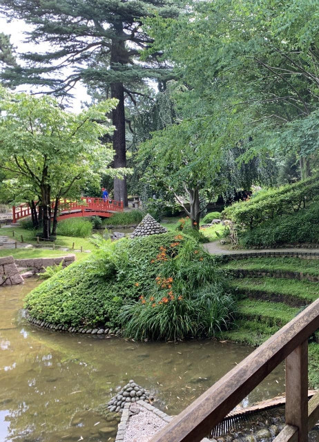 Depuis un pont piéton, un autre pont rouge au jardin japonais Albert Kahn. De l'eau, des arbres, arbustes, marches, un peu de fleurs. Au fond un mec qui m'a empêché de prendre la photo sans lui puisqu'il a traîné longtemps au bout du pont, admirant à juste titre la vue. D'accord, ça m'avait énervé.