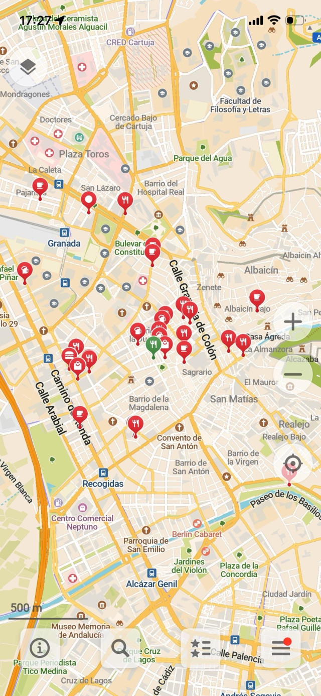 Mi lista de favoritos de Granada en la aplicación CoMaps. En los pines rojos sale un iconito del tipo de local que es (cuchillo y tenedor para restaurantes, taza para los cafés, etc). La interfaz es muy limpia, sólo se ve el mapa, con el estilo típico de OpenStreetMaps, los pines rojos y unos botones de acción abajo.