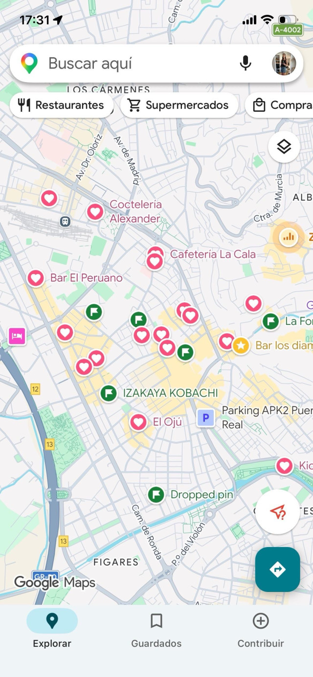 Mi lista de lugares en Google Maps. La interfaz está llena de botones de llamada a la acción, para buscar, dictar, editar la cuenta o buscar direcciones. Los pines rojos no son muy descriptivos: un corazón, una bandera o una estrella. Hay además resultados algunos lugares que yo no he guardado pero que probablemente sean sitios promocionados.