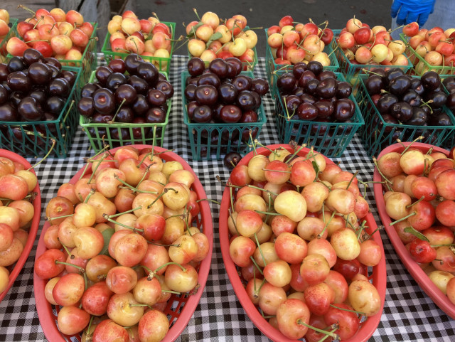 Baskets holding cherries: large baskets holding light-colored cherries and smaller baskets with either those same cherries or much darker ones. 