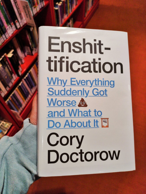 A photo of the cover of Cory Doctorow's book Enshittification in my hand.