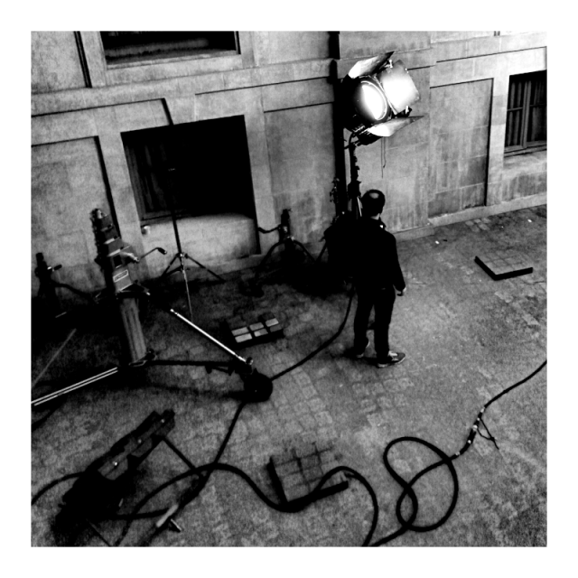 Monochrome indoor square format photography.

The other side of the settings, a light operator busy fine tuning the credibility.