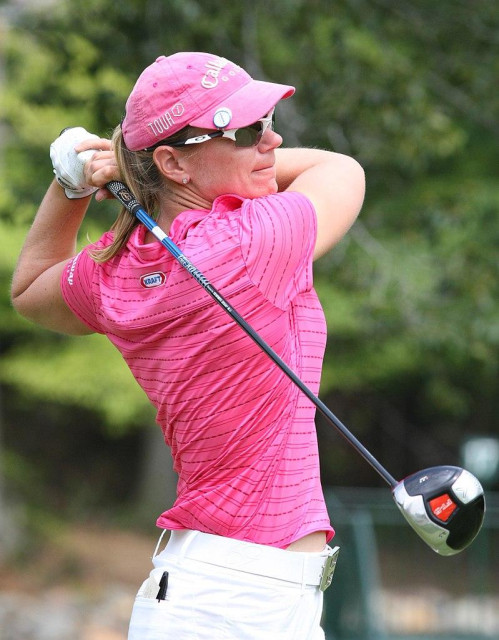 Annika Sörenstam having just teed off. She is a white woman with blonde hair, holding a golf club.

Photo is by Keith Allison.
