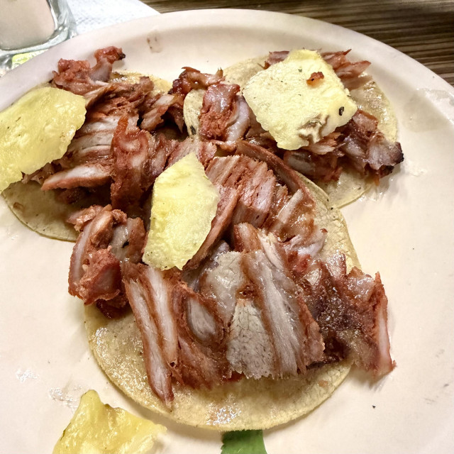 A photo of delicious al pastor tacos with pineapple 