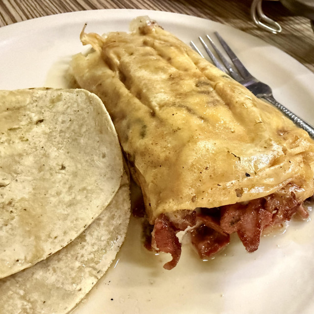 A photo of al pastor alambre with crispy cheese 