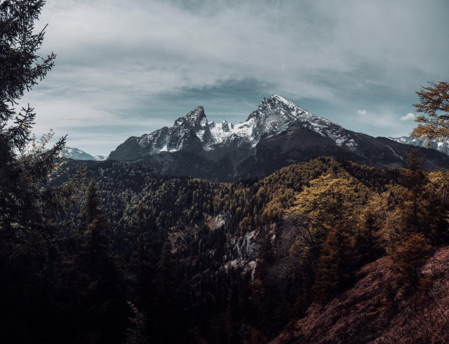 Mountain panorama of the Watzmann with distinctive peaks and forested slopes under a cloudy sky
