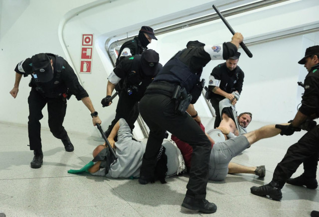 Spanish police savagely beating peace activists returning from illegal captivity after being detained and tortured by Israeli pirates.