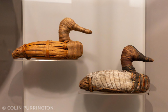 Duck models made from tule reed and cattail. The one on the right has white feathers secured with fine cord.
