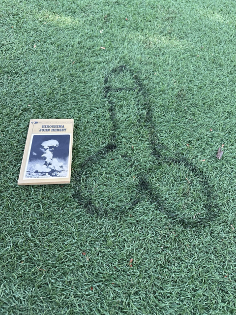 A copy of “Hiroshima”, by John Hersey, lying on the (dry! Book safe!) turf next to a big spray painted penis.