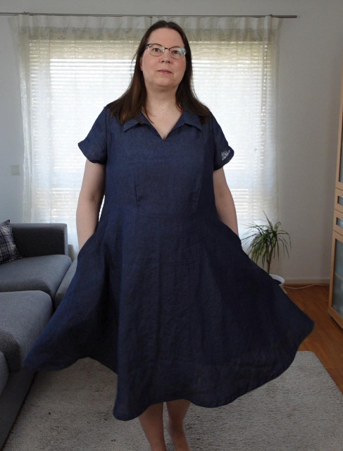 Full body image of a woman in a blue dress, showing it has pockets