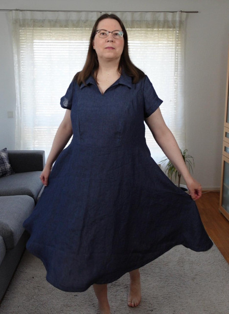 Full body shot of a woman in a blue dress showing the flowy half circle skirt