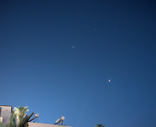 Twilight sky, with the corner of a building in the bottom left. The sky is a gradient from sky blue to deep blue. 
There are two obvious points of light in the sky, the brightest and lowest one is Venus, the other, higher in the sky is Jupiter. 
There are two bright stars above the planets. 