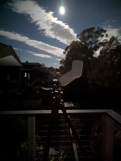 Photo of a Seestar smart telescope on a tripod, lit by moonlight