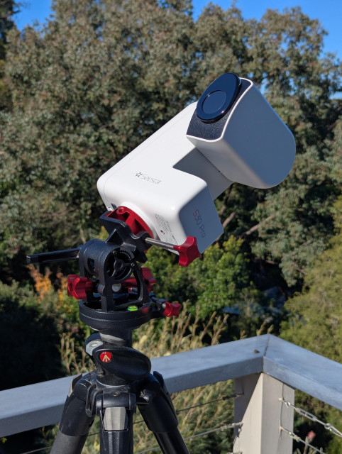 Photo of a Seestar S30 Pro smart telescope on a  tripod, during the day.