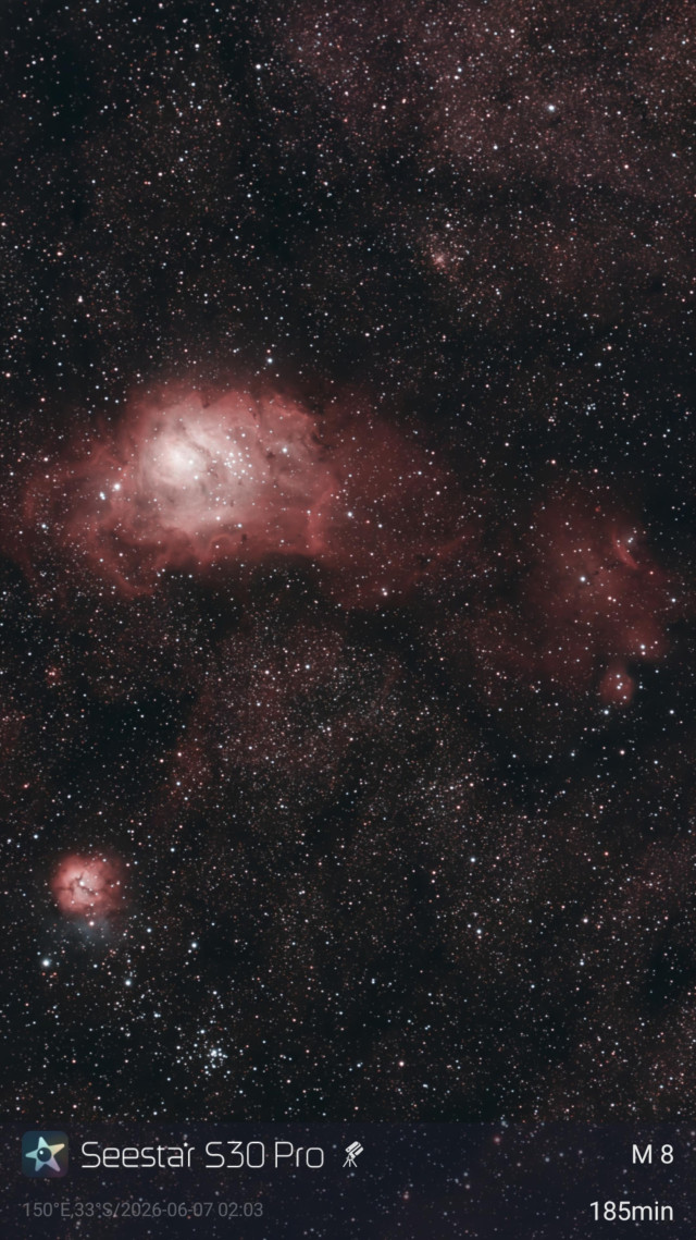 Image of a large emission nebula (Lagoon Nebula) with a smaller one below it (Triffid Nebula).