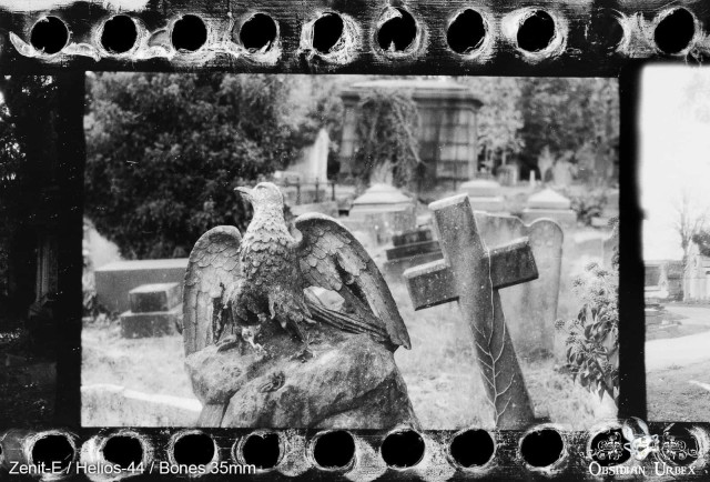 Photo of graveyard in black and white, eagle and cross