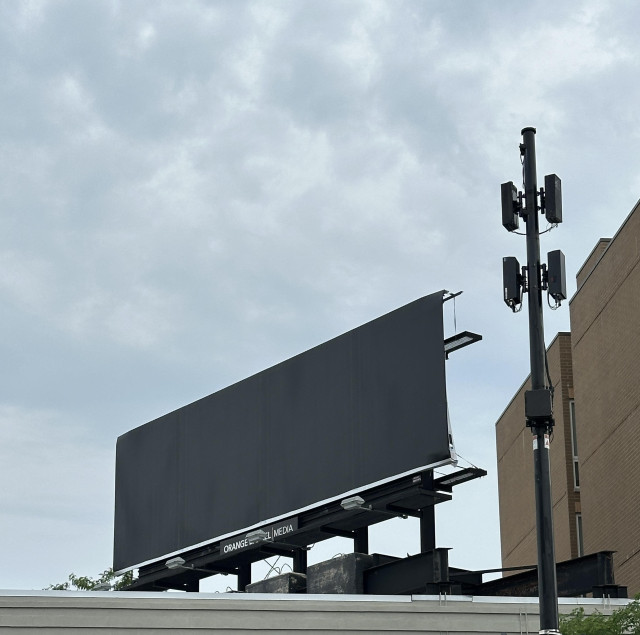 Black billboard, gray sky