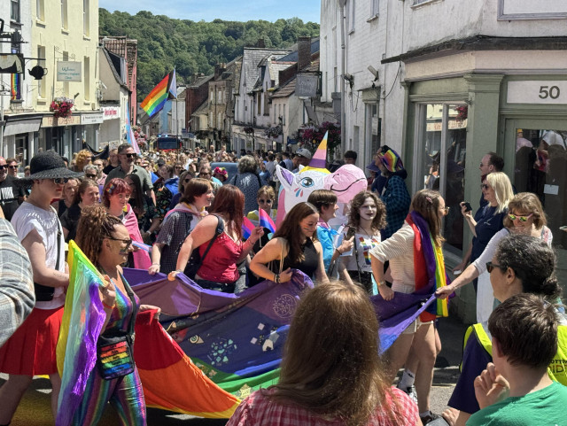 Pride parade on the high street with lots of flags etc.
