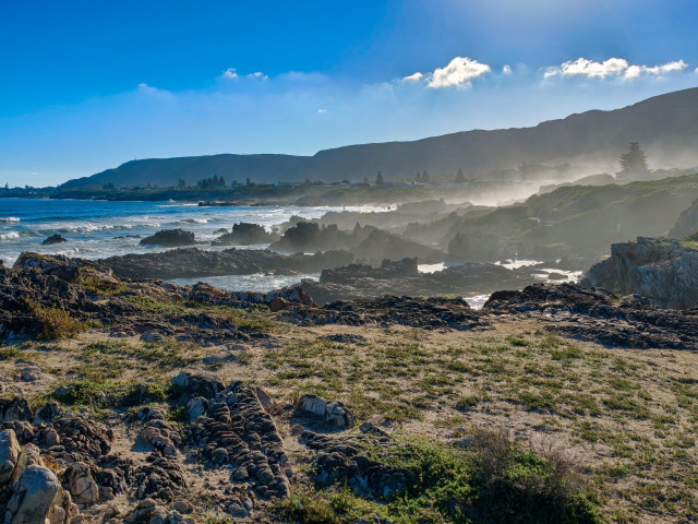 Sea spray creates a hazy scene along the rocky Hermanus coast, South Africa