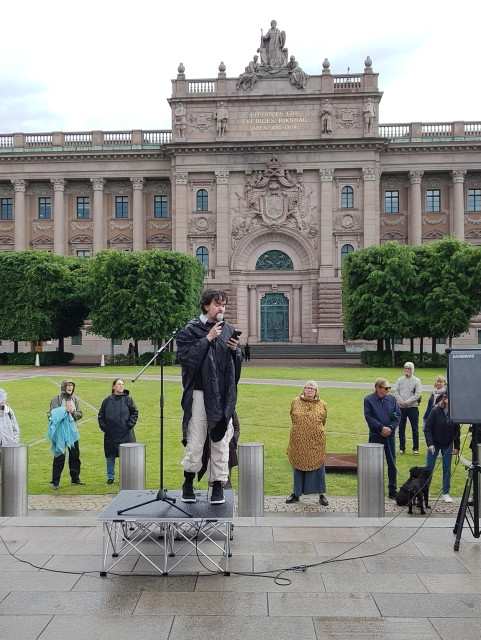 Bild på Leo Rudberg som talar framför riksdagshuset