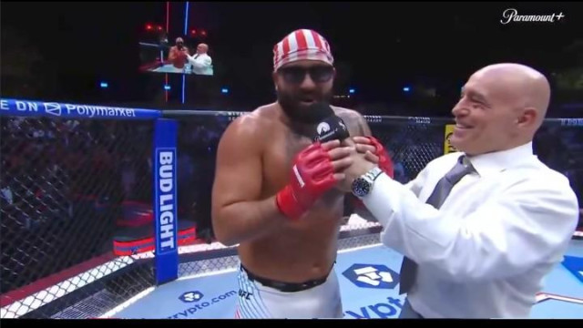 UFC fighter interviewed by Joe Rogan saying "Michelle Obama is a man!" The ring has logos from crypto.com, Polymarket and Bud Light. There is Paramount Plus logo in the upper right corner.