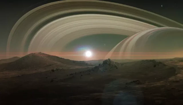 Vue d'artiste de la surface de Titan, la plus grande lune de Saturne. À l'horizon, Saturne et ses anneaux dominent le ciel au-dessus d'un paysage sombre et rocheux baigné d'une lumière orangée. © Vadim Sadovski / Shutterstock.com