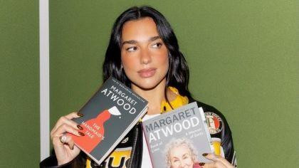 Dua Lipa holding books by Margaret Atwood
