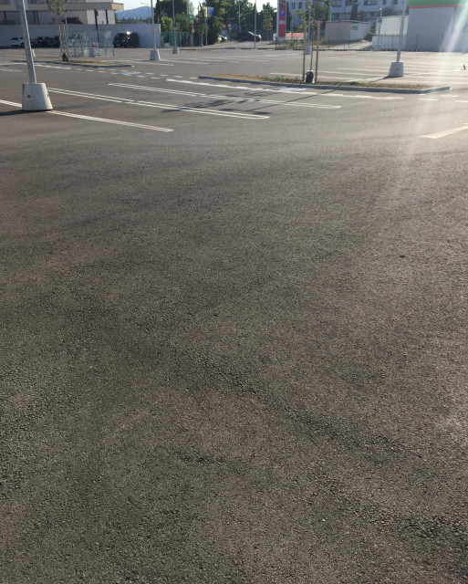 Foto von einem großen Supermarktplatz, große Asphaltfläche im Hintergrund Wohnhausanlage Foto: VCÖ