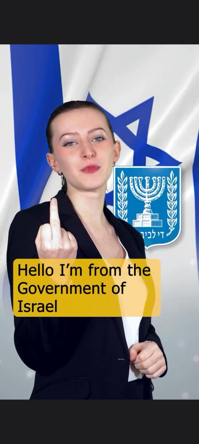 a woman speaking against a backdrop of an Israel flag and a coat of arms bearing a menorah.

she walks forward a step with her right arm extended, showing her middle finger, adding an undertone of "fuck you" to the camera. 

she says aloud "Hello, I'm from the Government of Israel" while the extended finger acts as a subtitle.
