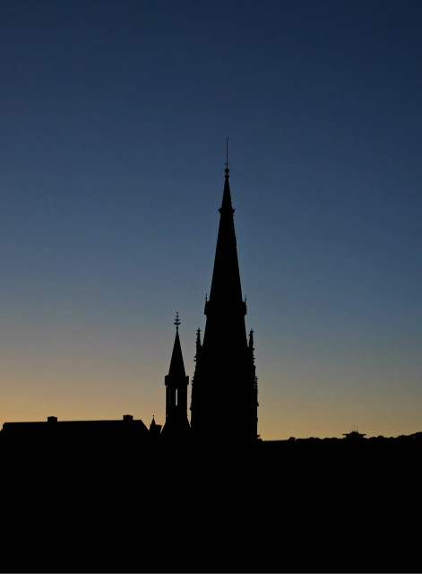 A photo of an evening sky with the silhouette of a church tower in the foreground.