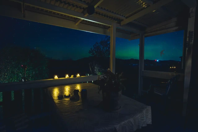 A photograph taken from a veranda, with the camera facing north. The Swedish west coast on a late summer evening. You can just make out the Northern Lights in the sky.