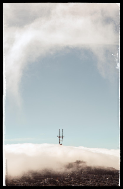 The view from Bernal Heights on a typical San Francisco day. It's summer. In the afternoon. And that means fog covers half the city and threatens to roll over another 25% within the next 2 hours.

In thiis photo, the tip of Sutro Tower peeks out from thick bank of fog covering Twin Peaks and Mount Sutro. Above Sutro Tower, there's a bit of clear blue sky... except for one swirl of fog that reaches up and arcs high above Noe Valley.

Our house, in Noe Valley, sits 2-3 blocks in front of the edge of the fog. Sometime between 5:00 and 6:00 p.m., the house will be in the fog. This is how it goes most days, from mid-May until September and occasionally throughout the other months of the year.