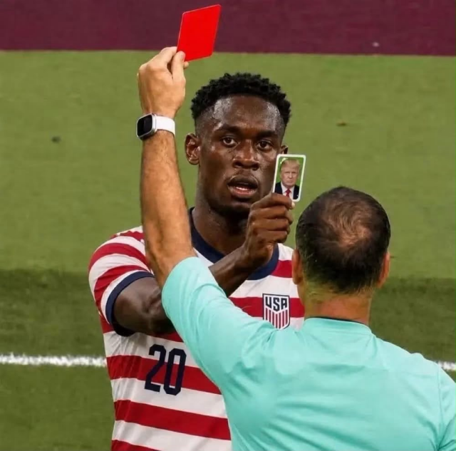 Folarin Balogun and the referee facing each other, holding up cards to show each other. Folarin’s card has Donald Trump’s face on it. The referee’s is a red card.