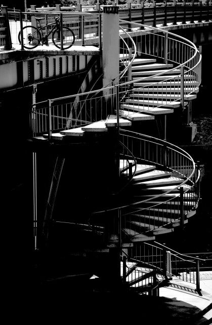 A bicycle considers the spiral staircase, but decides to wait for its owner.