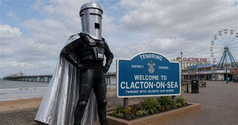 Count Binface stands by a sign saying Welcome to Clacton on Sea