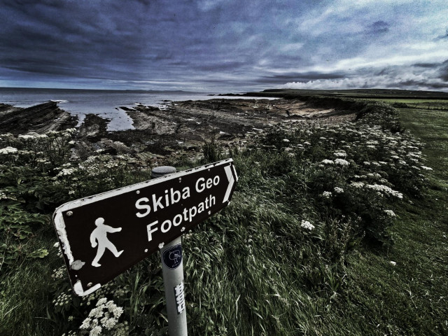 Sign for Skiba Geo footpath pointing along vast open coastline