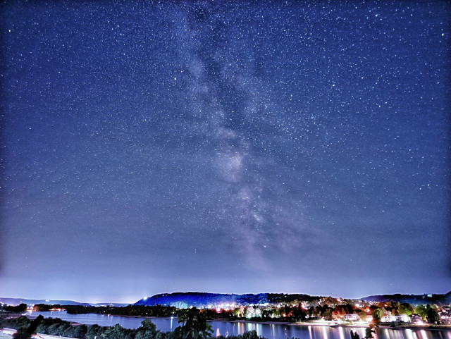 Nachts Blick auf den Rhein, darüber die Milchstraße 