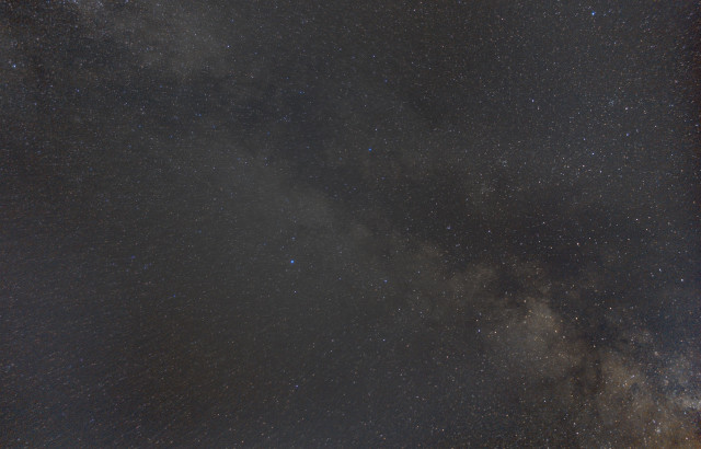 Picture of the night sky. Diagonally on the picture is a part of the milky way and around it a lot of stars