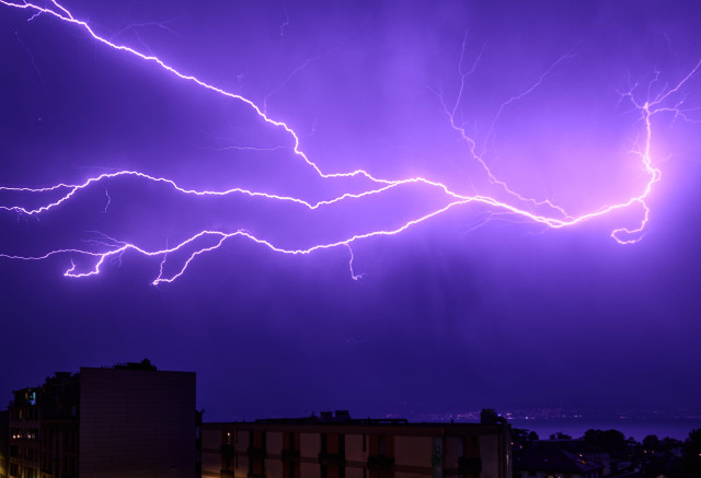 A nighttime photograph of a powerful lightning storm over Lausanne, Switzerland.