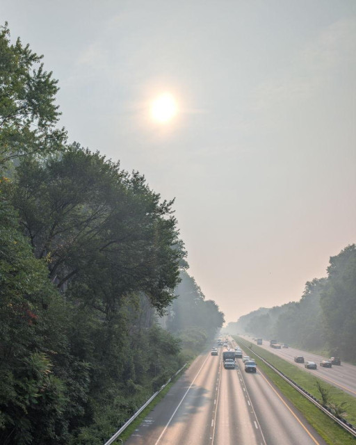 Interstate 495 in Maryland as seen from an overpass, a heavy haze of wildfire smoke becomes increasingly heavy as distance increases