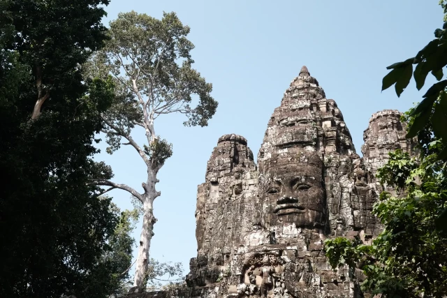 An old stone temple with a large sculpted face on the wall