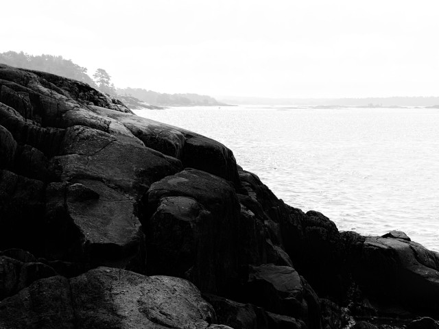 Black and white photo of cliffs by the sea formed by ice