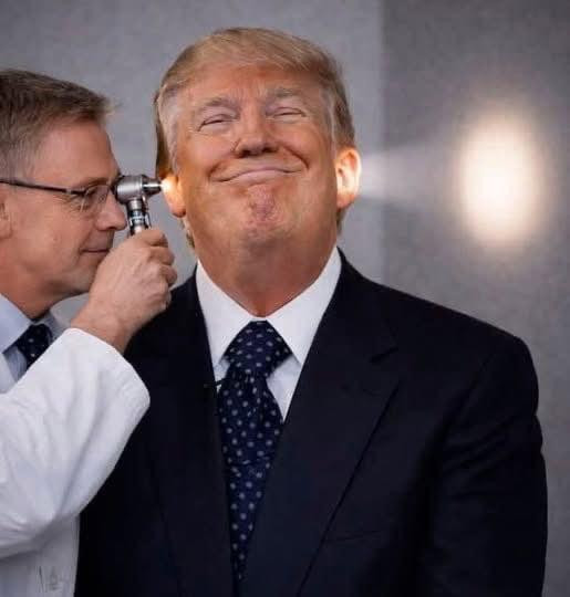 A doctor slinging a light in Dump Trump’s ear while the light beams out from his other ear indicating a missing brain