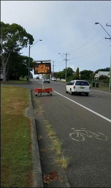 A large sign imploring motorists to "Give Cyclists Space" has been parked in the bike lane.