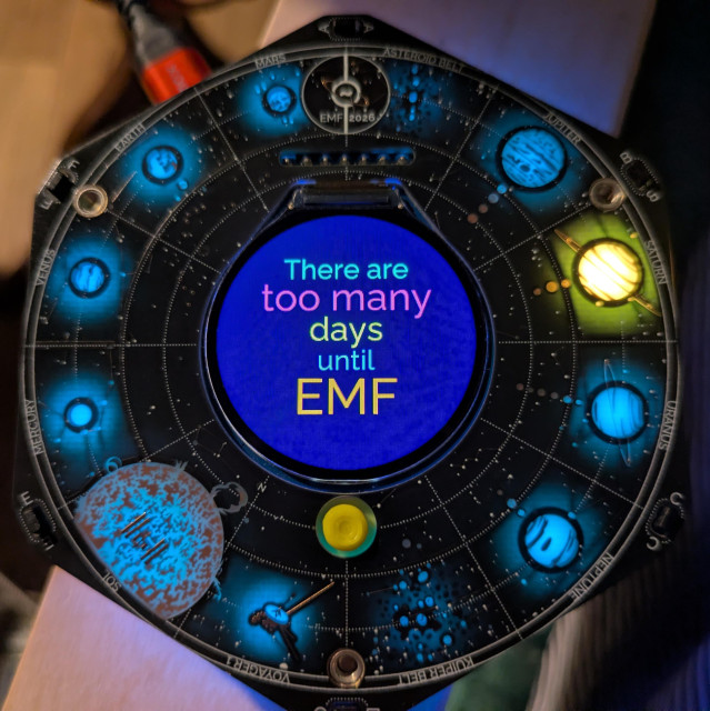 An EMF Tildagon badge saying "There are too many days until EMF"