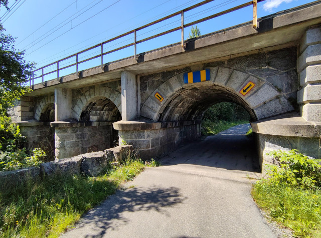 En väg under en murad järnvägsbro.