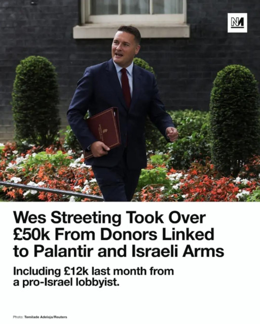An image shows a Wes Streeting wearing a dark blue suit and red tie walking outdoors past manicured green bushes and colorful flowers near a stone building. The individual is carrying a brown folder under one arm. A logo with the letter "N" is in the top right corner. Large bold text reads, "Wes Streeting Took Over £50k From Donors Linked to Palantir and Israeli Arms," followed by the subtext, "Including £12k last month from a pro-Israe pro-Israel lobbyist." At the bottom left, the text says, "Photo: Temilade Adelaja/Reuters".